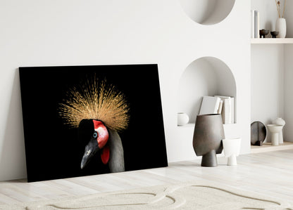 Black glass wall art featuring a crowned crane with golden crest and red face against dark background, leaning against white wall.
