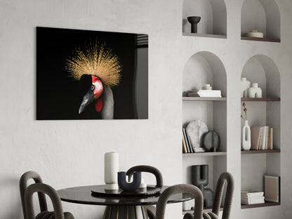 Glass wall art featuring crowned crane with golden crest and red face on black background, displayed above black dining table in modern interior.