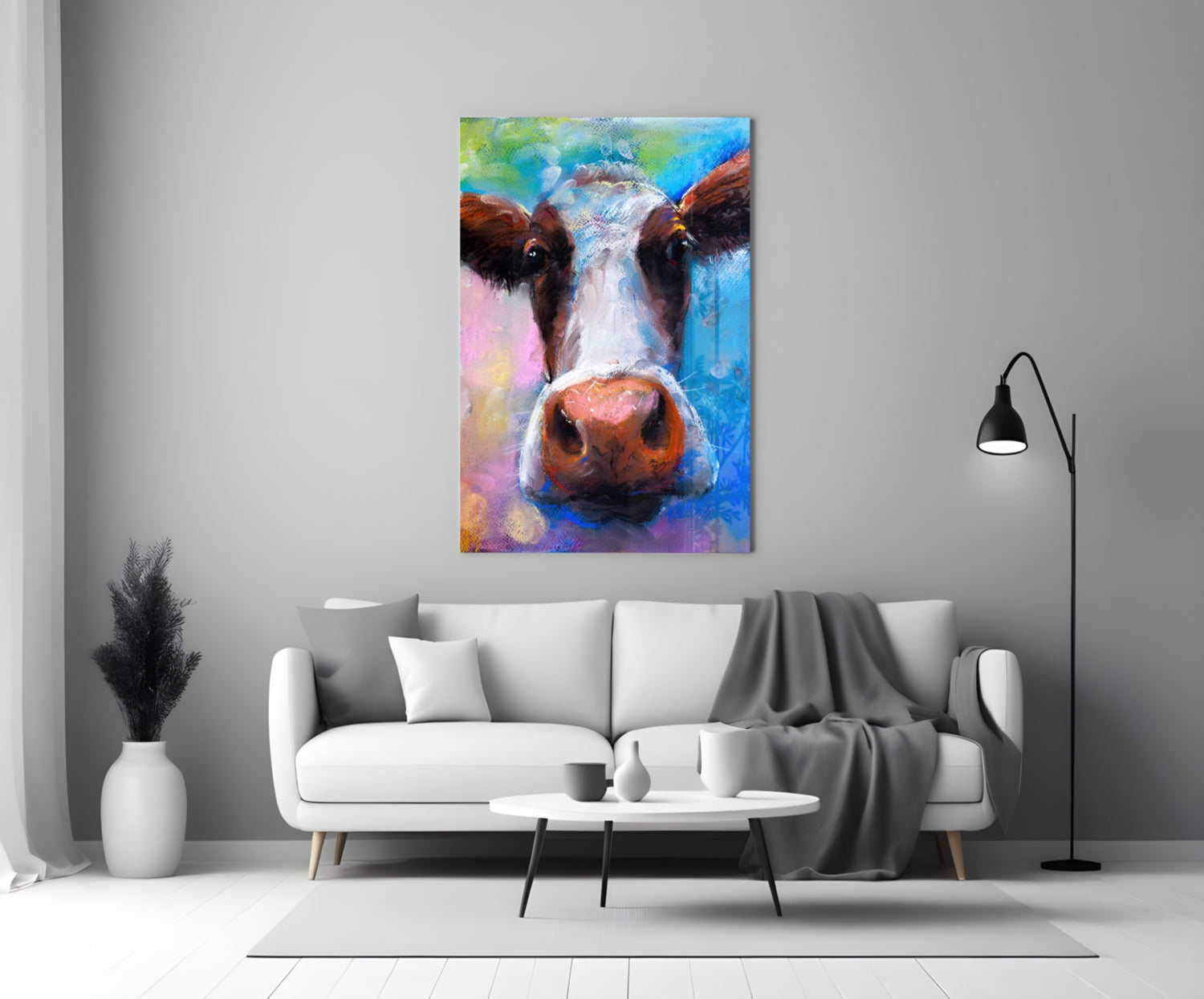 Colorful glass cow portrait with brown, white, and pink tones hung above white sofa in modern living room.
