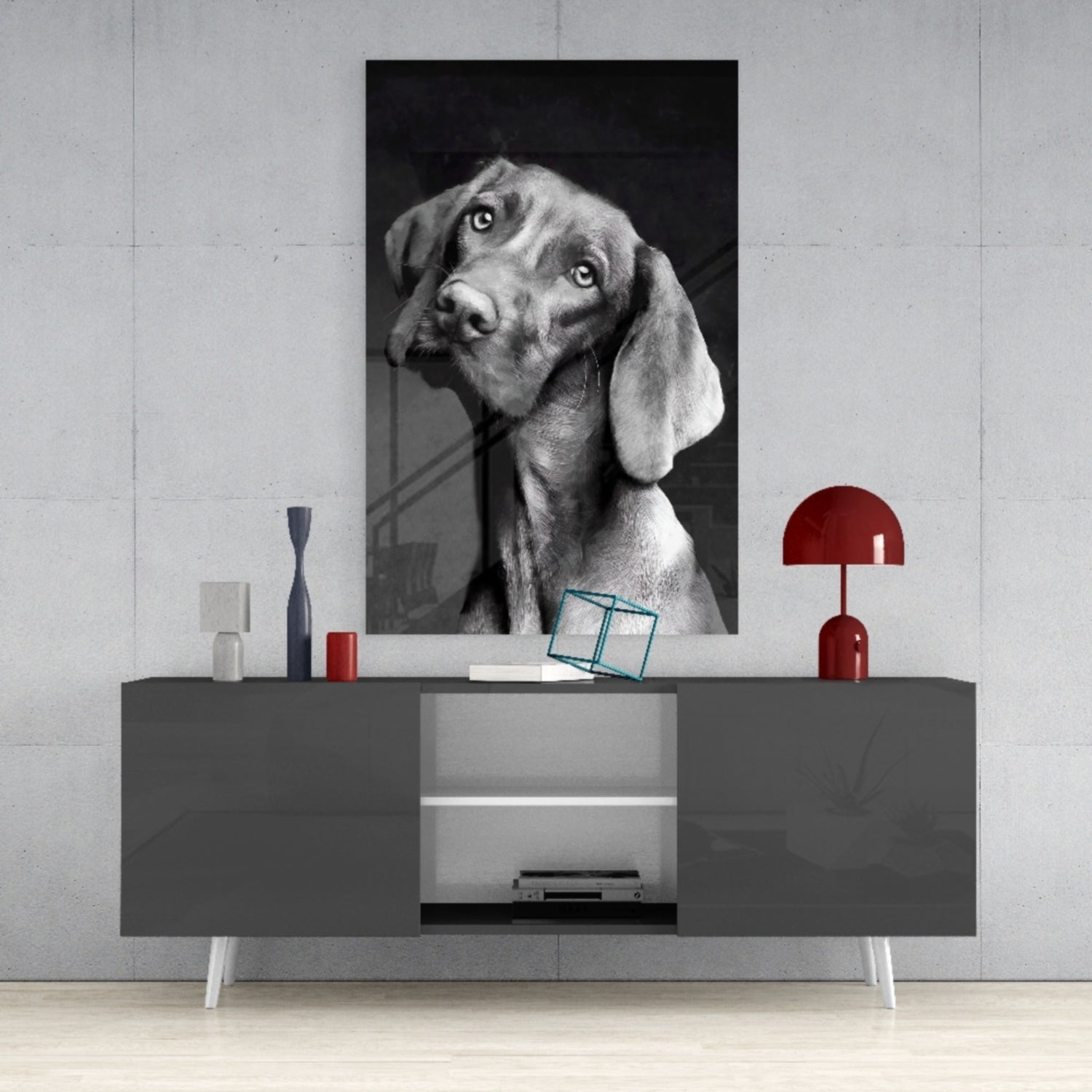 Black and white portrait of a dog with tilted head displayed on glass above gray media console with red accents.