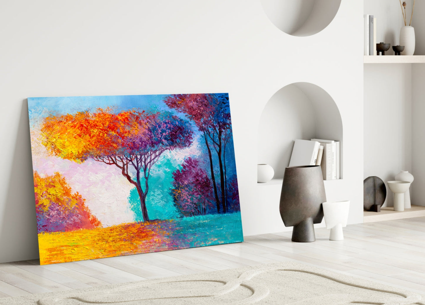 Colorful glass art leaning against white wall displays vibrant autumn trees in orange, yellow, purple, and teal hues.