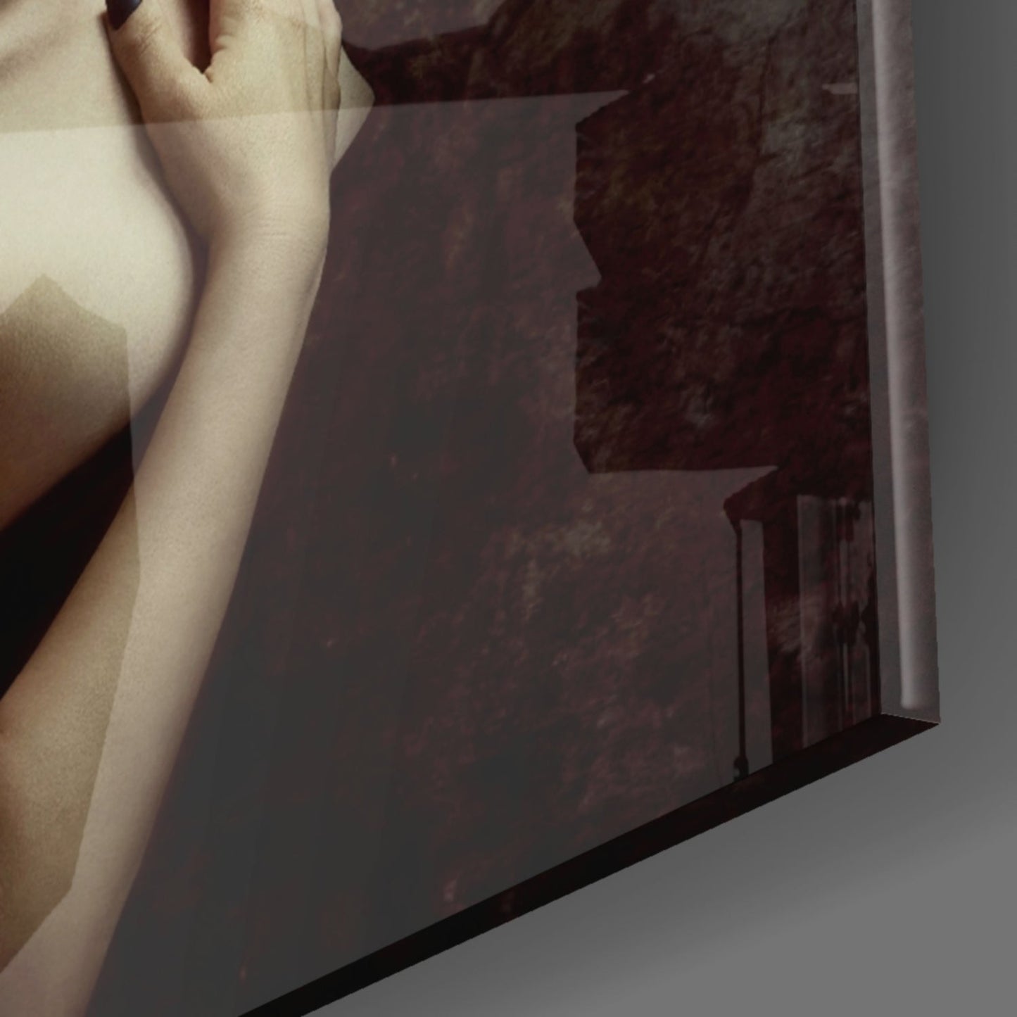 Close-up detail of glass wall art showing a pale female arm and shoulder against dark textured glass background.