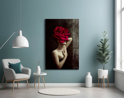 Glass wall art displaying a woman with a large red rose covering her face, mounted on a teal wall in a modern living room setting.