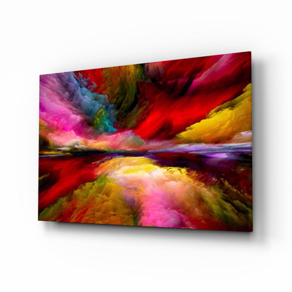 Angled perspective of colorful glass wall art depicting a vibrant landscape with red, pink, yellow, and blue hues reflecting across a water horizon.