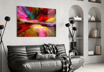 Colorful abstract glass wall art with vibrant pink, red, yellow, and blue streaks displayed above a black leather sofa in a modern living room.
