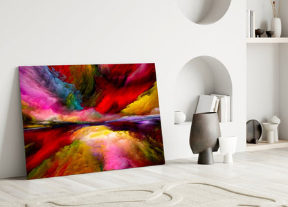 Colorful abstract glass wall art leaning against white wall in minimalist interior setting with decorative objects.