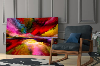 Vibrant multicolored glass wall art displaying swirling red, pink, yellow, and blue hues displayed in a modern living room next to a wooden chair.