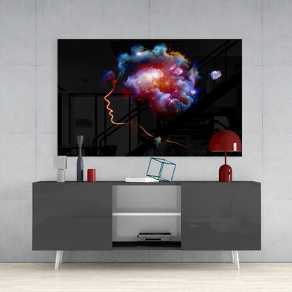 Glass wall art displaying glowing neon profile with vibrant cosmic galaxy cloud above, mounted on gray media console in modern interior.