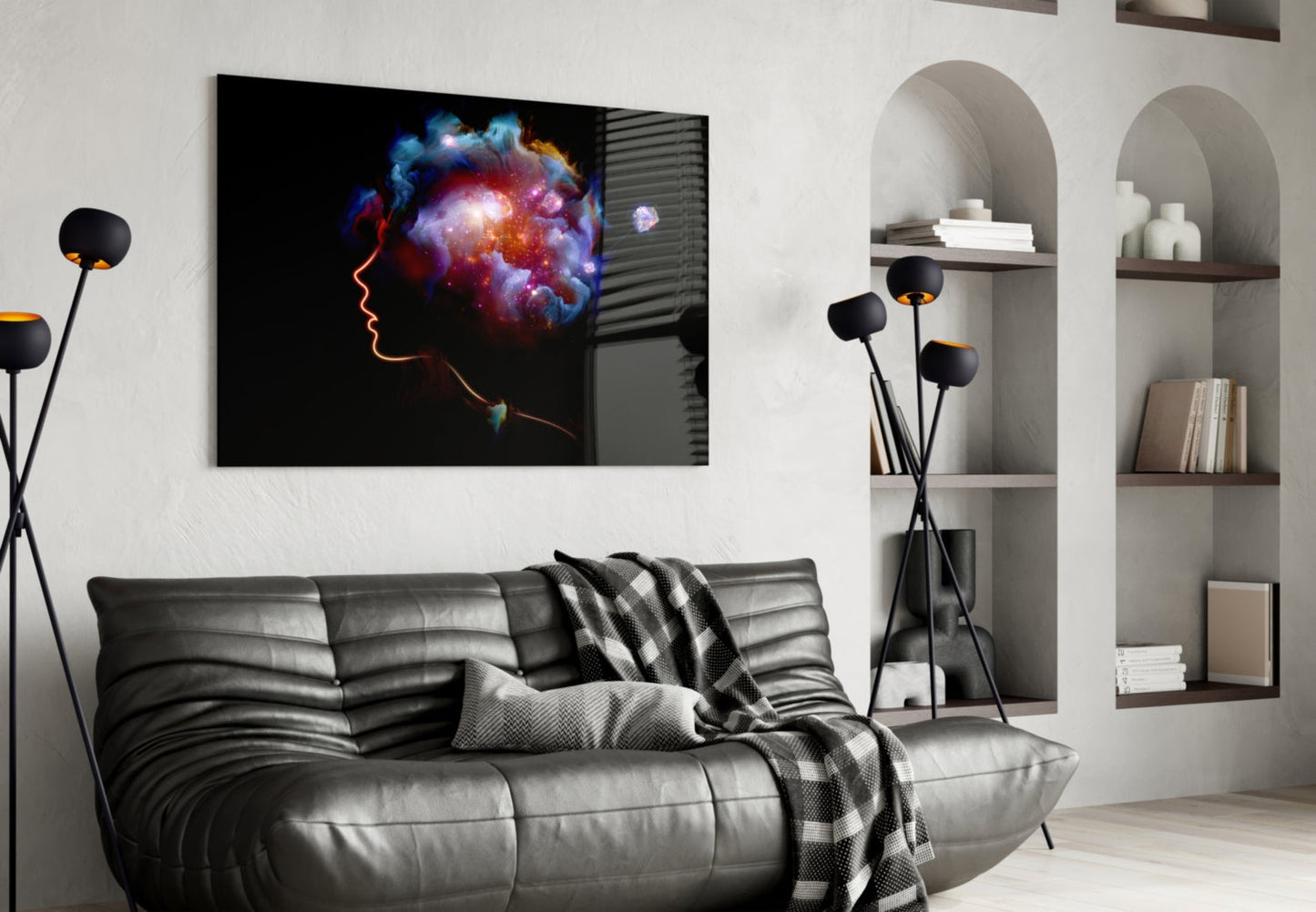 Glass wall art depicting a colorful cosmic mind illustration displayed above a gray leather sofa in a modern living room setting.