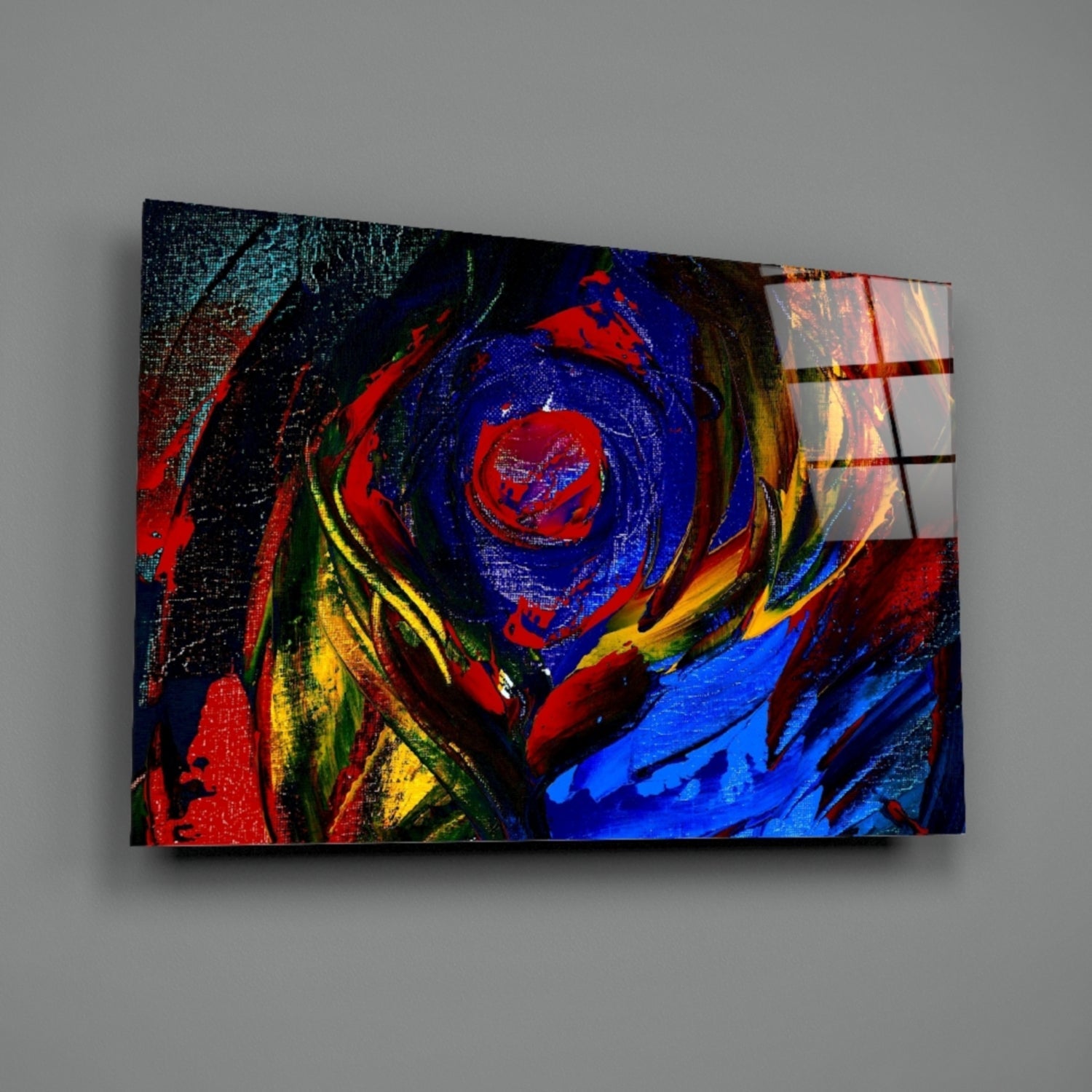 Angled view of a glass wall art print with vibrant red, blue, yellow, and black swirling abstract design mounted on gray wall.