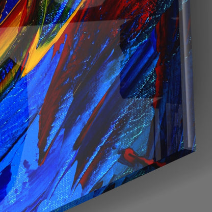 Close-up angled view of glass wall art with bold diagonal brushstrokes in blue, red, yellow, and gold paint.