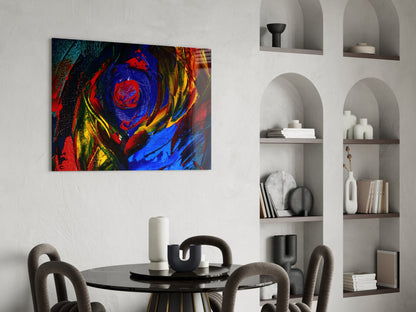 Vibrant abstract oil painting glass art with red, blue, and yellow swirls displayed above a dining table in a modern interior.