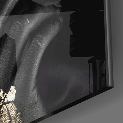 Close-up of textured gray fabric with gold accents held against black glass wall art panel.