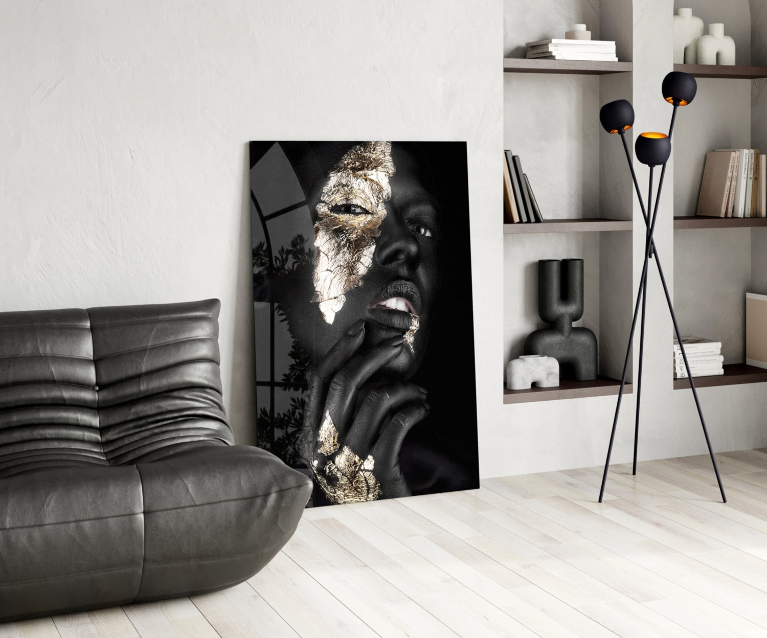 Black and gold glass wall art depicting a woman's face in profile displayed in a modern living room setting.