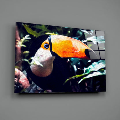 Colorful glass wall art of a toucan with orange beak and white chest against dark background with green foliage, mounted on gray wall.