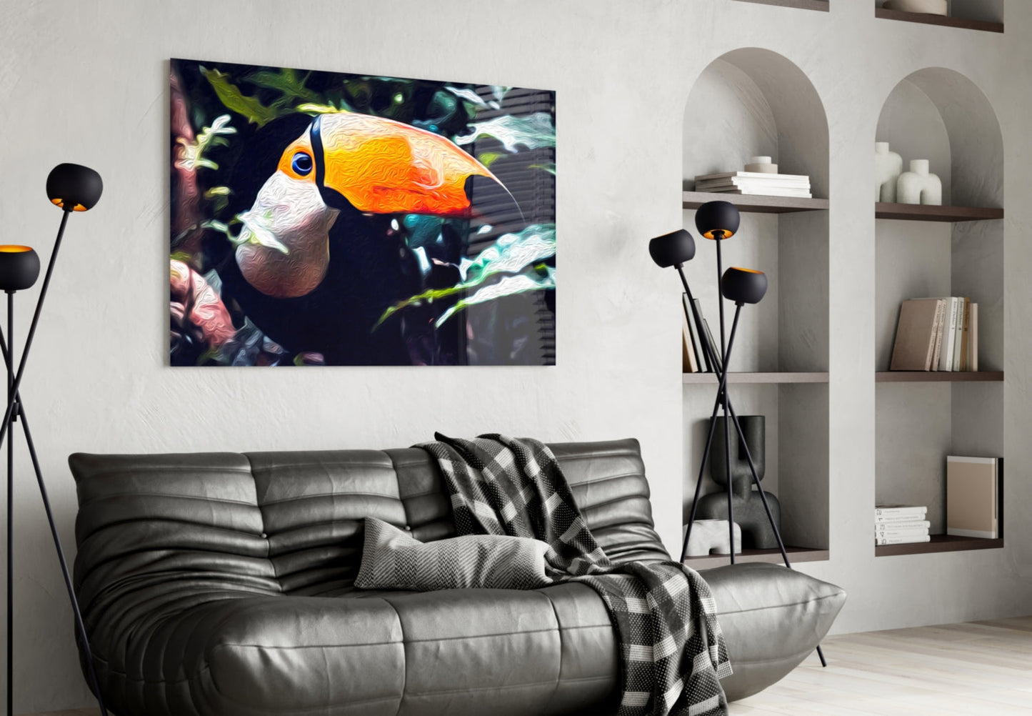 Toco Toucan glass wall art displayed above a gray sofa in a modern living room with white shelving and black floor lamp.