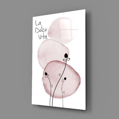 Angled view of glass wall art featuring pink watercolor flowers with thin black stems and "la Dolce Vita" text on white background.
