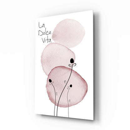 Pink watercolor circles with black stem figures and "la Dolce Vita" text on white glass panel, angled perspective view.