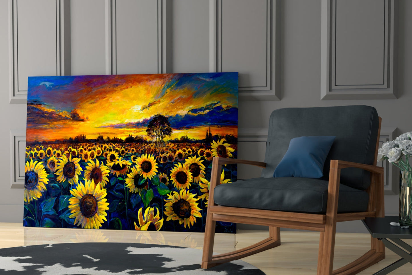 Vibrant glass wall art displaying golden sunflowers under a dramatic orange and blue sunset sky, displayed in a modern room setting beside a wooden chair.