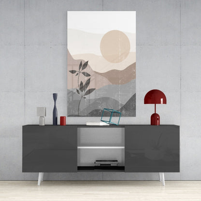 Modern minimalist wall art depicting layered mountains, a pale sun, and a dark botanical plant stem displayed above a dark gray media console.