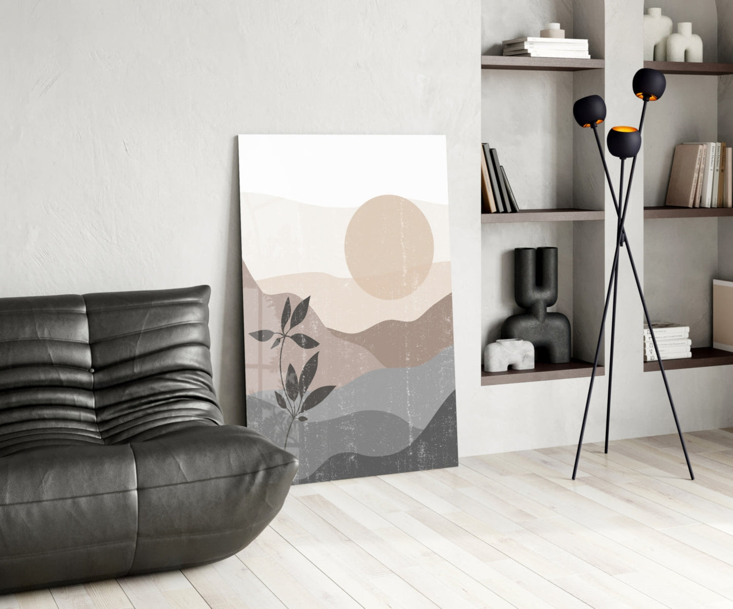 Small Leaves Glass Wall Art leaning against wall in modern living room with black sofa, floor lamp, and shelving unit.