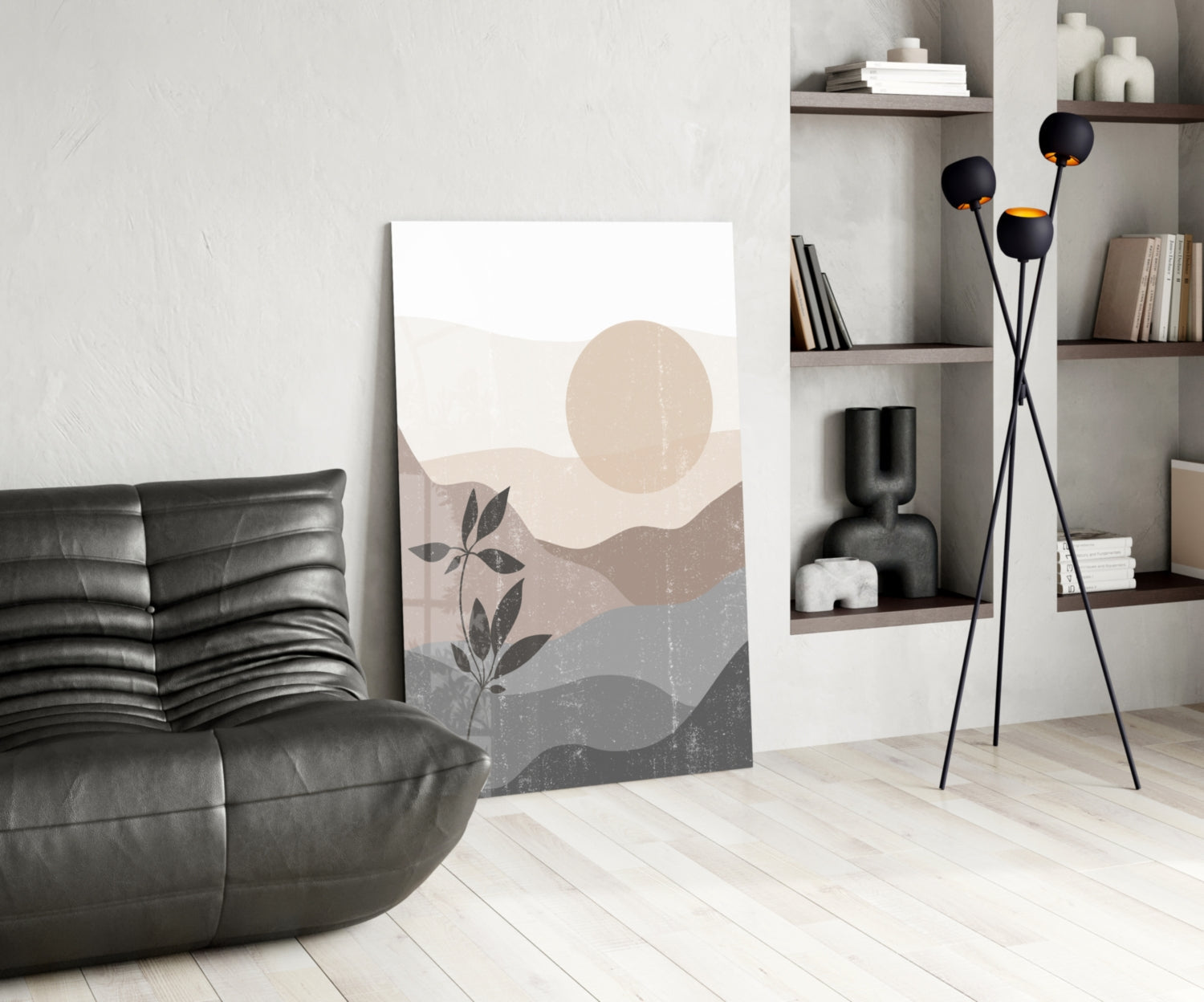 Small Leaves Glass Wall Art leaning against wall in modern living room with black sofa, floor lamp, and shelving unit.