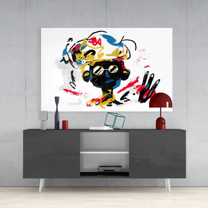 Colorful abstract glass wall art with black, yellow, red, and blue brushstrokes displayed above a gray media console in a modern interior.