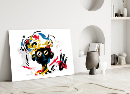 Colorful abstract glass wall art leaning against white wall in minimalist interior, featuring black, yellow, red, and blue brushstrokes.