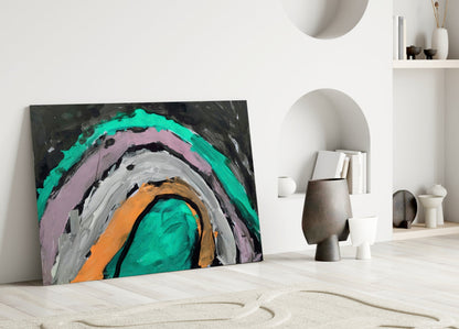 Colorful abstract glass art with concentric circles in turquoise, pink, gray, orange, and black, leaning against white wall in minimalist interior.