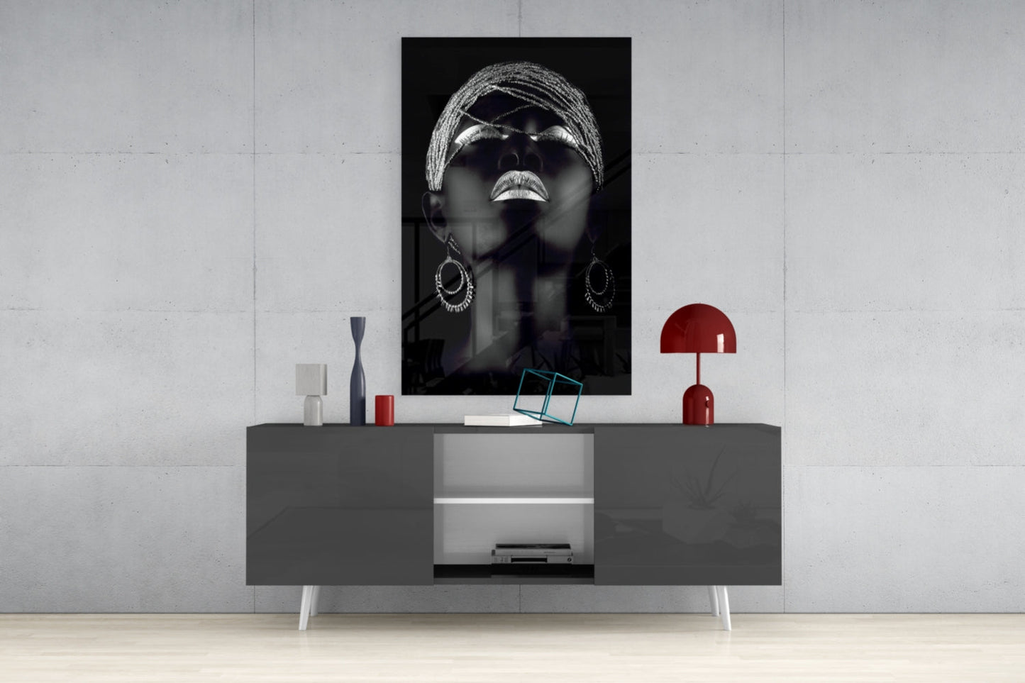 Black and white portrait of woman wearing sunglasses and hoop earrings displayed above modern gray console table with red accents.