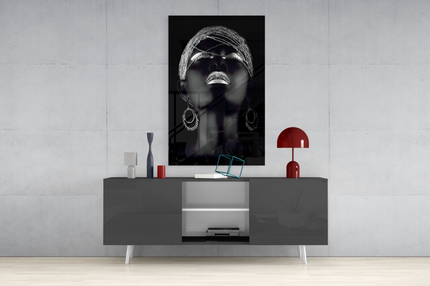Black and white portrait of woman wearing sunglasses and hoop earrings displayed above modern gray console table with red accents.