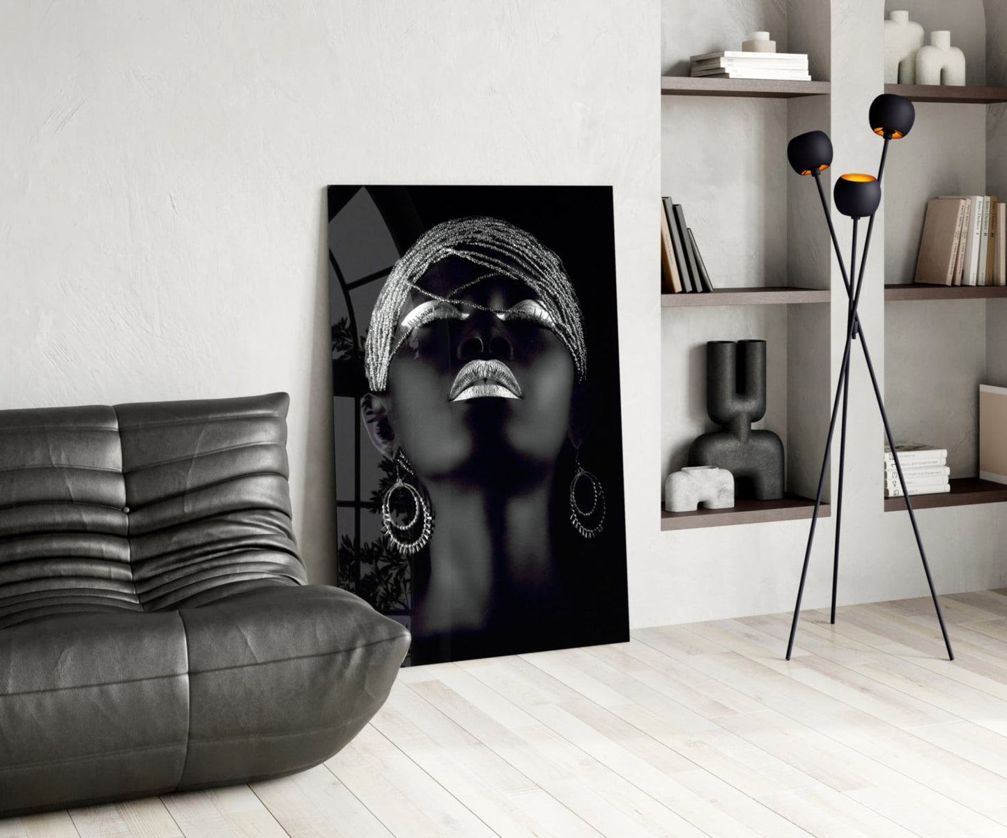 Black and white glass wall art featuring a woman with sunglasses and head wrap, displayed in modern living room setting.