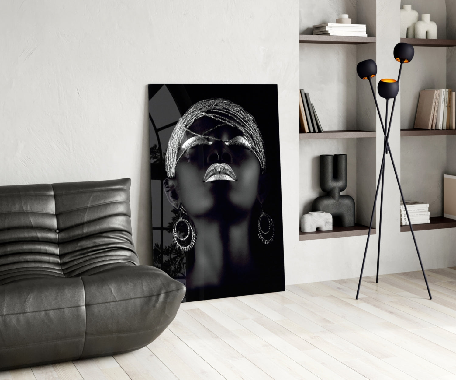 Black and white glass wall art featuring a woman with sunglasses and head wrap, displayed in modern living room setting.