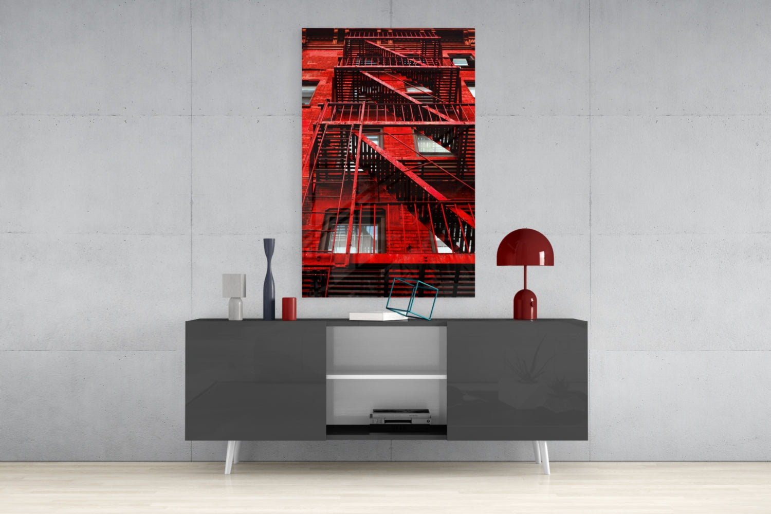 Red metal fire escape stairs photographed from below against a red brick building facade, displayed as wall art above a gray media console.