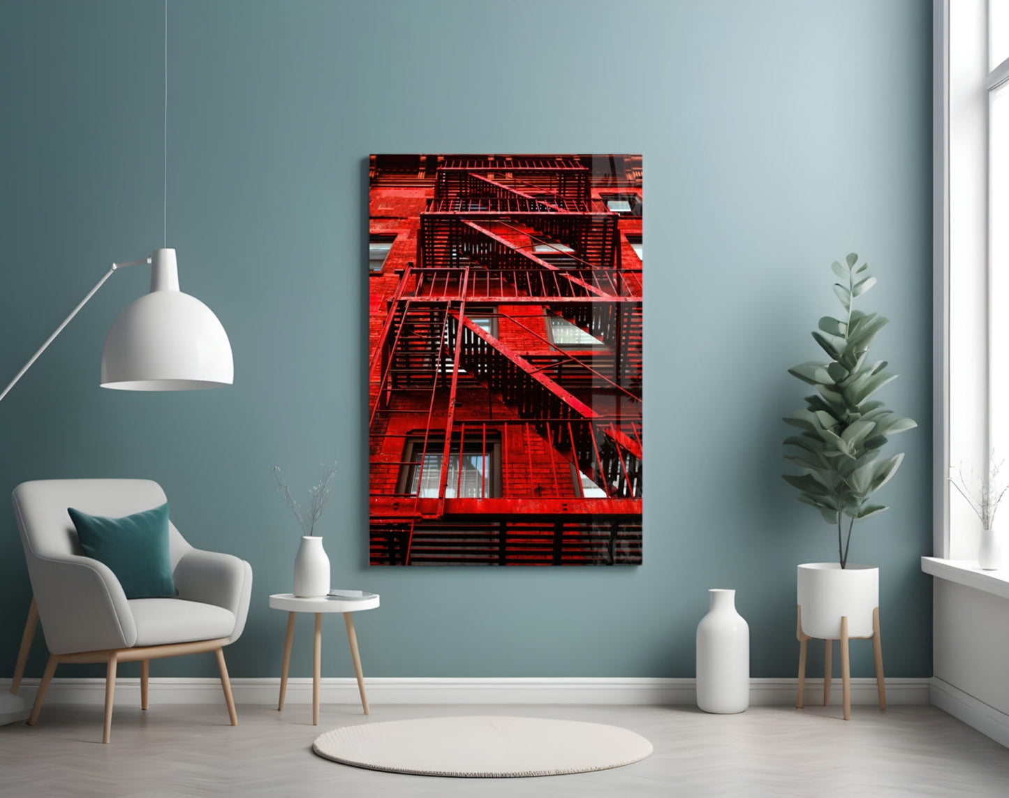 Red metal fire escape stairs on brick building displayed as glass wall art in modern teal room with chair and plants.
