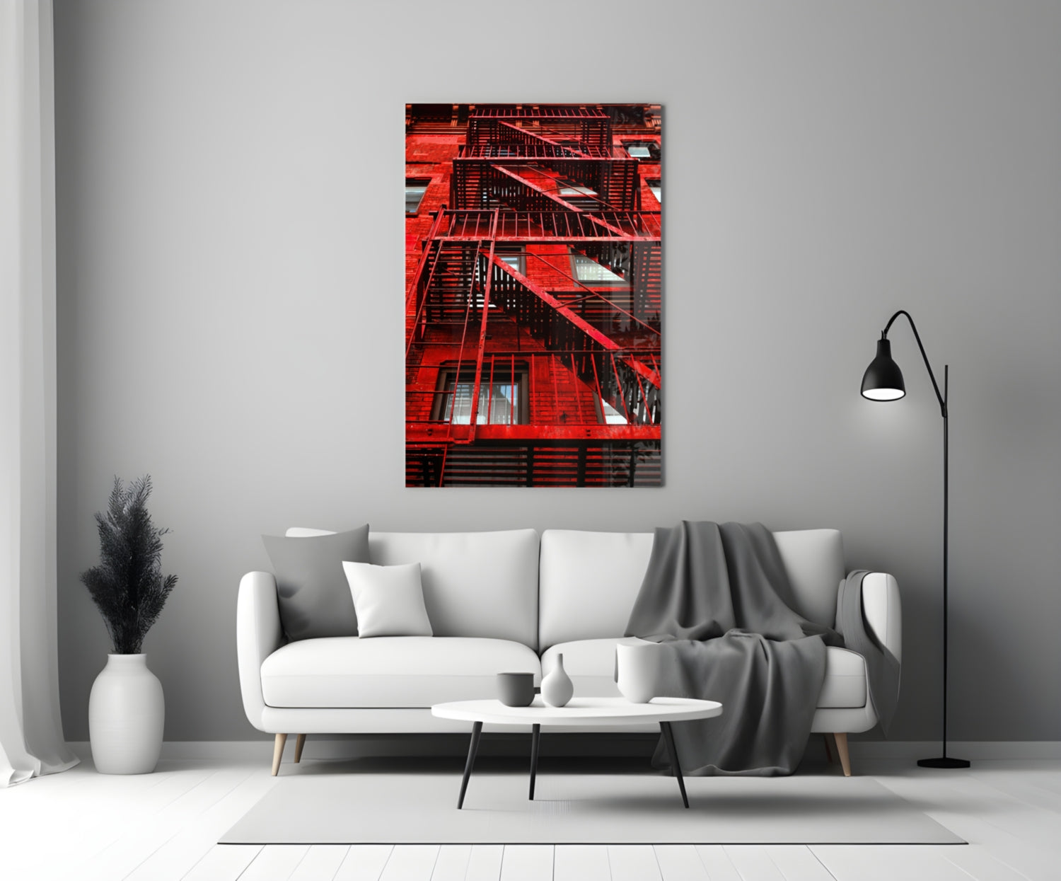 Red brick building facade with black metal fire escapes displayed as glass wall art above white sofa.