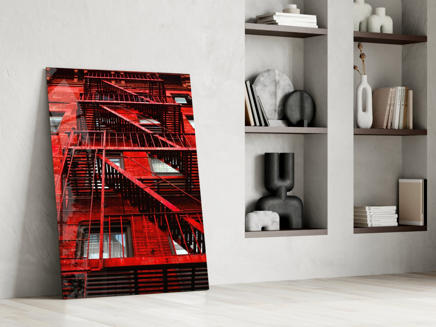 Red Stairs glass wall art leaning against white wall beside shelving unit with decorative objects and books.