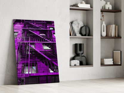 Purple Stairs Glass Wall Art leaning against white wall beside shelving unit with books and decorative objects.