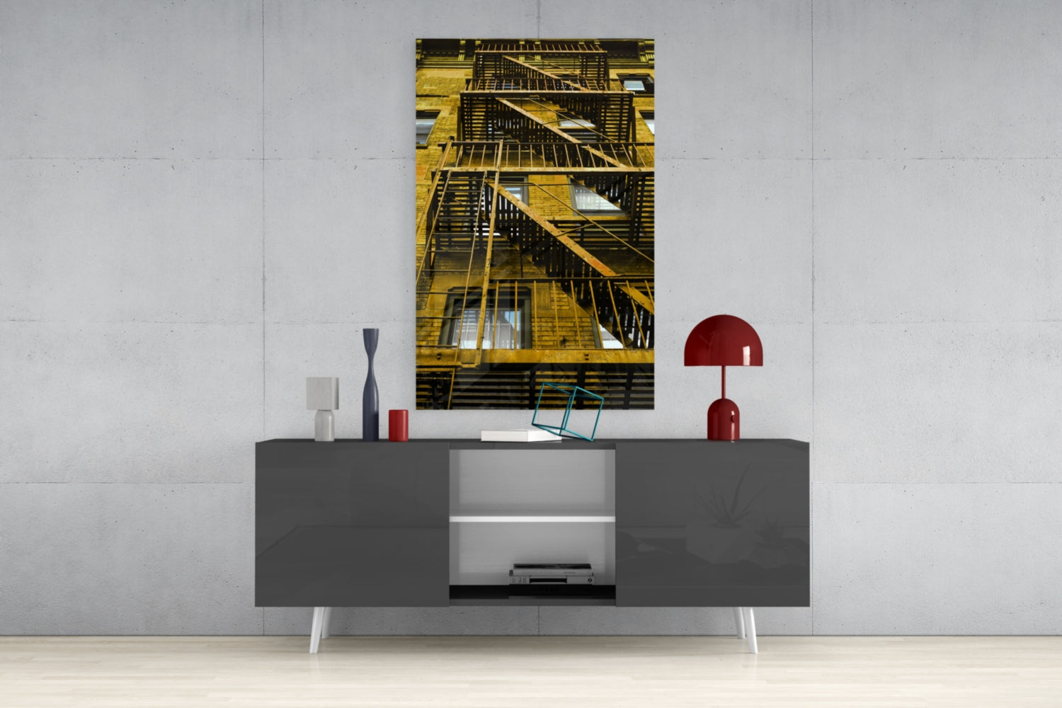 Yellow metal fire escape stairs on building facade displayed as vertical glass wall art above gray media console.
