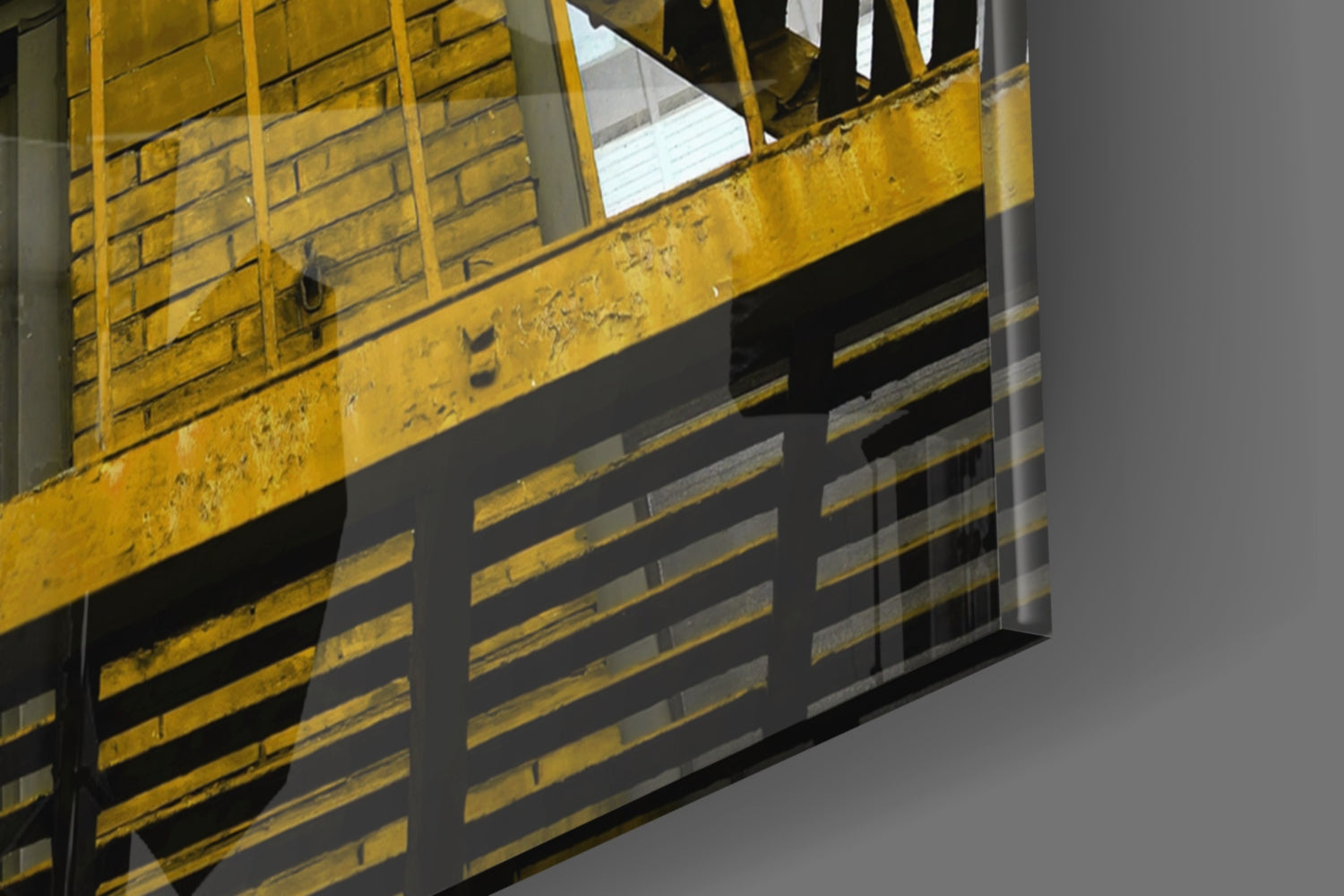 Close-up view of yellow and black metal stair treads with industrial safety stripe pattern against gray background.