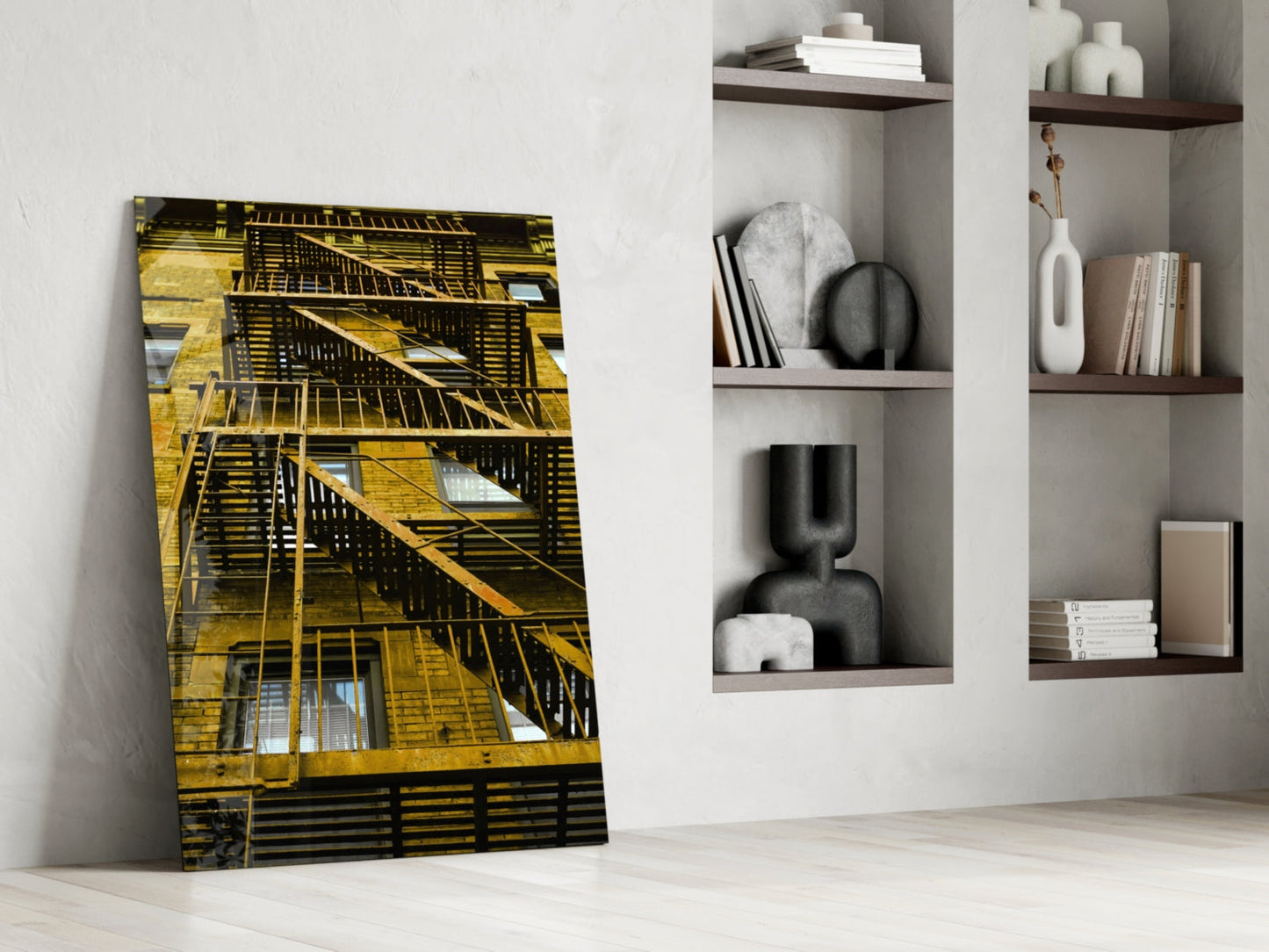 Yellow Stairs glass wall art leaning against white wall next to built-in shelving with decorative objects and books.