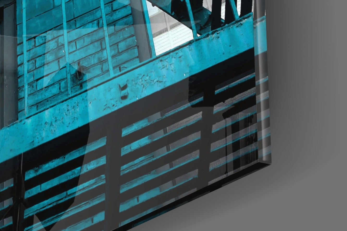 Angled view of turquoise metal staircase with horizontal railings and glass wall panel casting shadows.