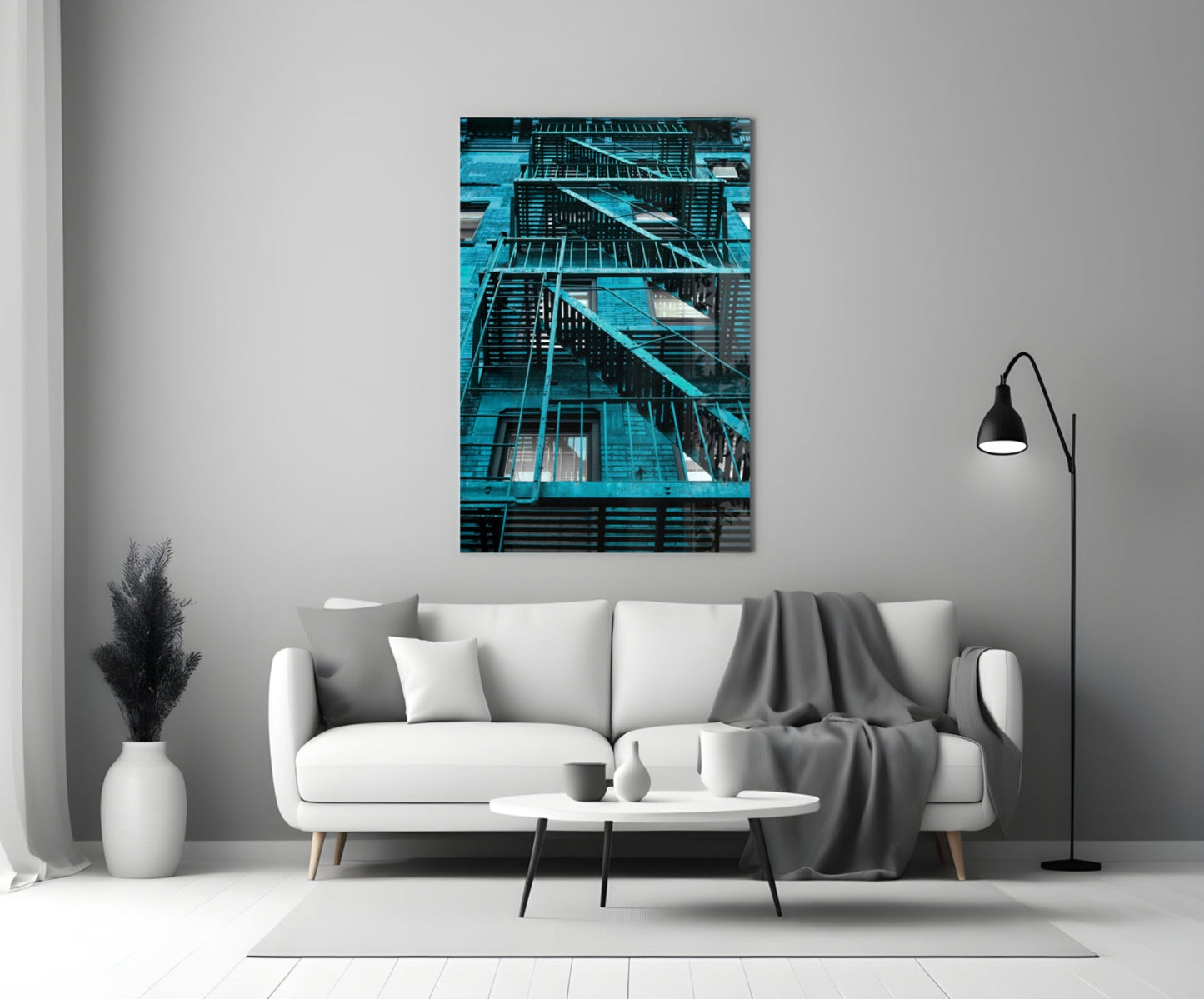 Turquoise-toned glass wall art depicting external fire escape stairs on a residential building, displayed above a white sofa in a modern living room setting.