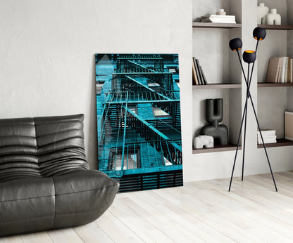 Blue Stairs Glass Wall Art displayed in modern living room beside gray leather chair and black floor lamp with shelving.