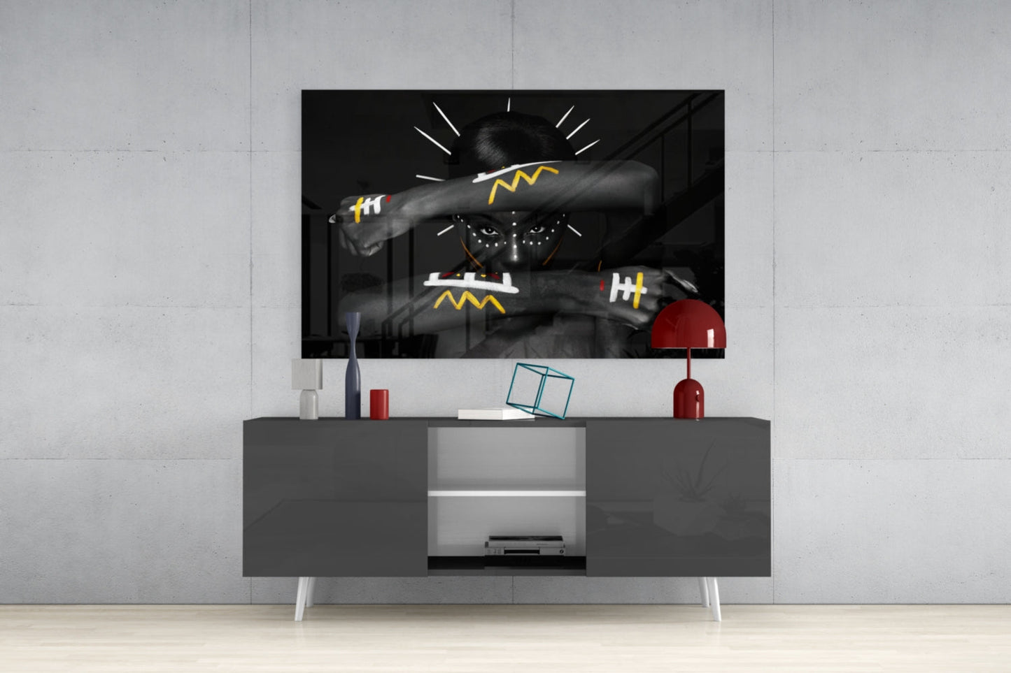 Black and white glass wall art with yellow geometric patterns displayed above gray media console in modern living room setting.