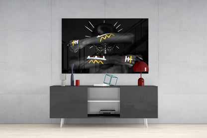 Black and white glass wall art with yellow geometric patterns displayed above gray media console in modern living room setting.
