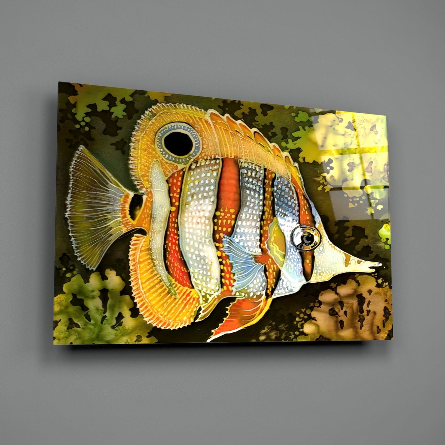 Colorful glass wall art depicting an orange and white striped tropical fish with detailed fins against a dark background with coral silhouettes.