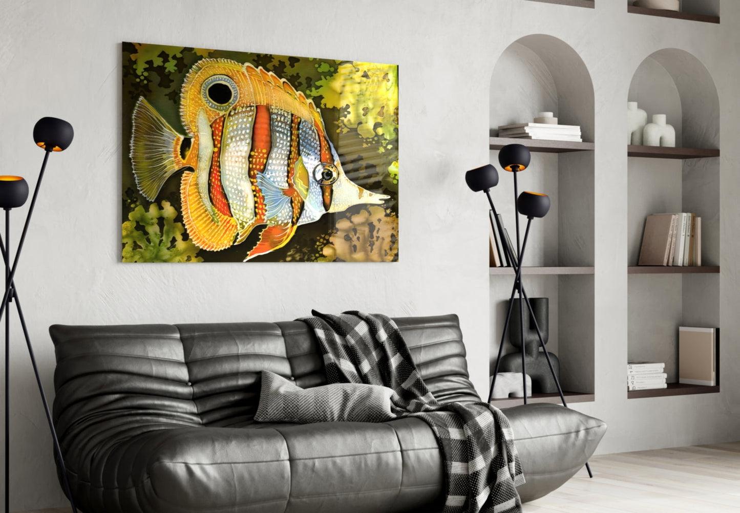 Colorful striped orange and white fish glass wall art hanging above black leather sofa in modern living room with built-in shelving.