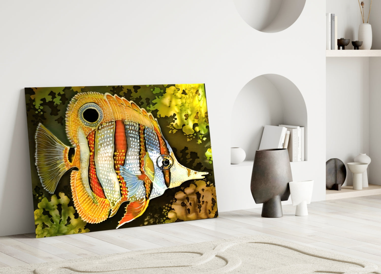 Colorful glass wall art depicting an orange and white striped tropical fish displayed in a minimalist white room setting.