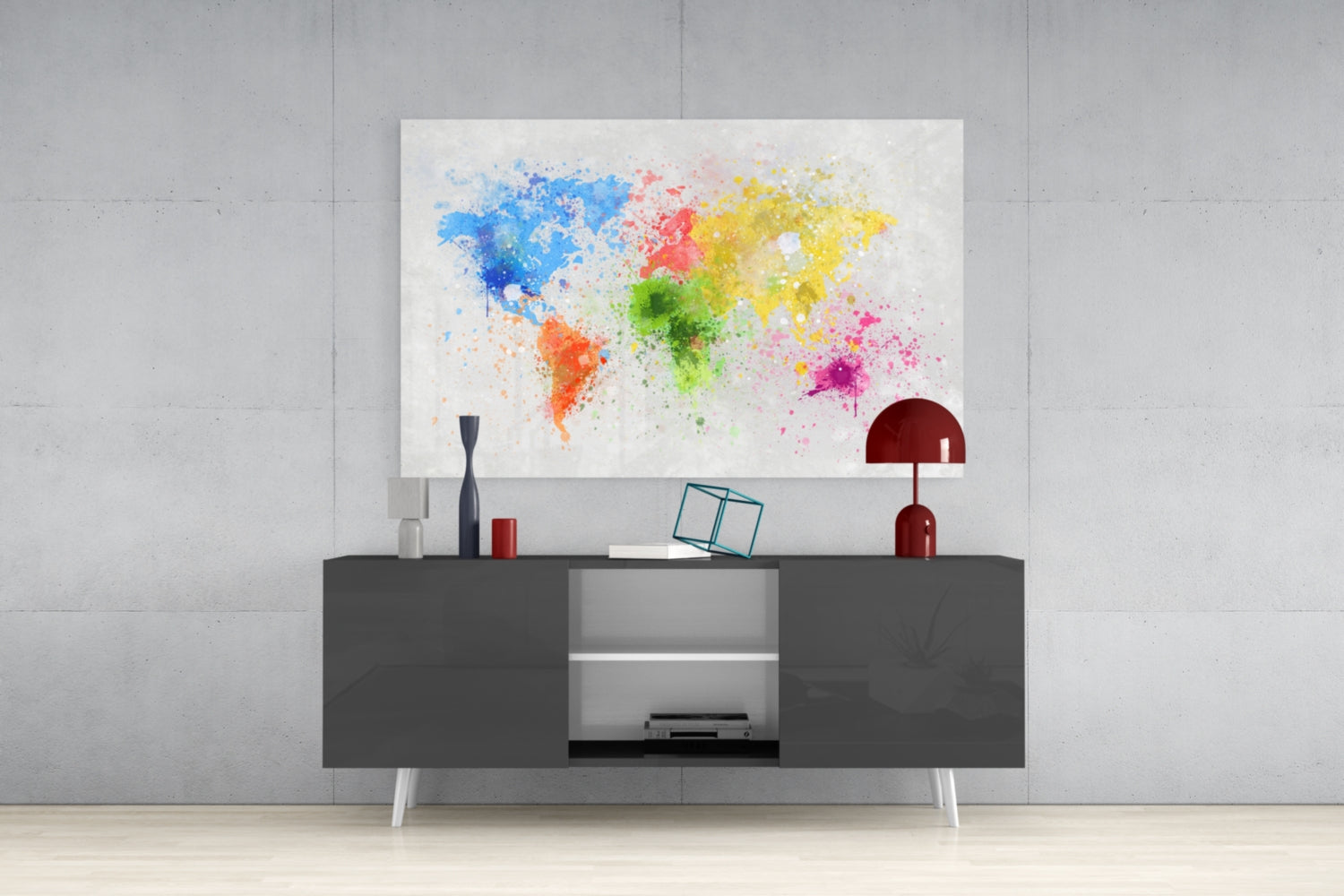 Colorful watercolor world map glass art displayed above dark gray console table with red lamp and decorative accessories.